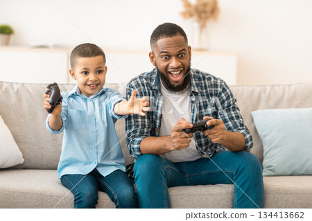 Videogames. African American Father And Son Having Fun Playing Video Game Together Bonding At Home. Young Daddy And Little Kid Boy Spend Weekend Play Computer Games Concept 134413662