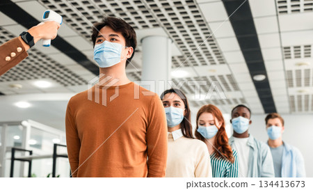 New Normal, Pandemic Outbreak Concept. Teacher Doing Temperature Screening Measuring Fever For Diverse Group Of People Standing In Queue, Using Infrared Contactless Themometer At The Entrance New Normal, Pandemic Outbreak Concept. Teacher Doing Temperature Screening Measuring Fever For Diverse Group Of People Standing In Queue, Using Infrared Contactless Themometer At The Entrance 134413673