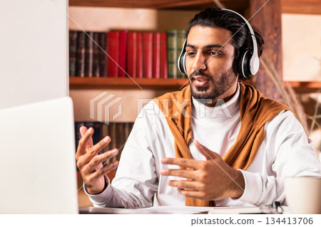 Indian Teacher Teaching Online Having Webinar Sitting At Laptop Making Video Call Communicating With Students Indoor, Wearing Headphones. E-Teaching, Distance Lesson, Modern Education Concept Indian Teacher Teaching Online Having Webinar Sitting At Laptop Making Video Call Communicating With Students Indoor, Wearing Headphones. E-Teaching, Distance Lesson, Modern Education Concept 134413706