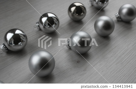 Christmas baubles in silver shades with different textures on a gray wooden surface Christmas baubles in silver shades with different textures on a gray wooden surface 134413941