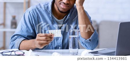 Headache Treatment. African American Man Reading Medicine Pills Instruction And Side Effects Touching Aching Head Sitting At Workplace Indoors. Migraine Medication Concept. Selective Focus 134413981