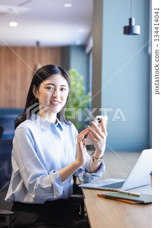 Business woman with a smartphone Business woman with a smartphone 134414041
