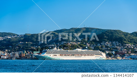 Panorama from the opposite shore of the passenger ship (Norwegian Spirit) arriving at Nagasaki Port [Nagasaki City] 134414107