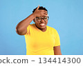 Sick African American Woman Having Fever Touching Hot Forehead Suffering From Flu Symptom Standing Over Blue Studio Background. Illness, Covid-19 Coronavirus Disease Concept 134414300