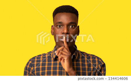It's A Secret. Young Black Guy Making Shh Silence Gesture, Mysterious African Man Putting Finger On Lips And Looking At Camera While Standing Isolated Over Yellow Background, Closeup Shot, Copy Space It's A Secret. Young Black Guy Making Shh Silence Gesture, Mysterious African Man Putting Finger On Lips And Looking At Camera While Standing Isolated Over Yellow Background, Closeup Shot, Copy Space 134414606