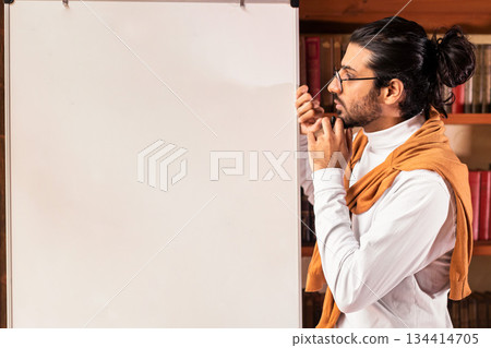 E-Teaching Concept. Thoughtful Indian Teacher Man Standing Near Blackboard With English Grammar Rules Teaching Student Online Indoor. Remote E-Learning And Modern Education E-Teaching Concept. Thoughtful Indian Teacher Man Standing Near Blackboard With English Grammar Rules Teaching Student Online Indoor. Remote E-Learning And Modern Education 134414705