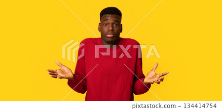 I Don't Know. Doubtful African American Guy Shrugging Shoulders And Spreading Arms, Unsure Black Guy Can't Decide What To Do, Standing Isolated Over Yellow Studio Background, Copy Space 134414754