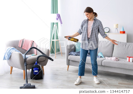 Disgusted millennial lady standing in messy flat after party, not willing to do cleanup, empty space. Sickened female student at dirty college dorm room after celebration, garbage lying everywhere 134414757