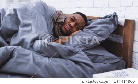 Unhappy Sick Black Guy Lying Wrapped In Blanket Suffering From Covid-19 Symptoms, Anxiety And Panic Attack In Bedroom At Home. Covid-19 Coronavirus Depression, Flu Disease Concept. Selective Focus Unhappy Sick Black Guy Lying Wrapped In Blanket Suffering From Covid-19 Symptoms, Anxiety And Panic Attack In Bedroom At Home. Covid-19 Coronavirus Depression, Flu Disease Concept. Selective Focus 134414860