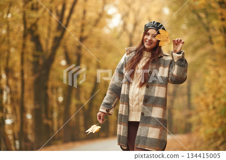 Positive facial expression. Happy woman is in the autumn forest Positive facial expression. Happy woman is in the autumn forest 134415005