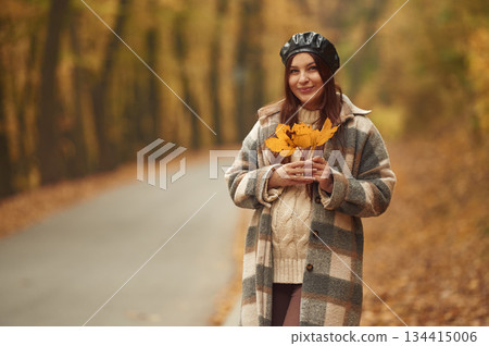 Positive facial expression. Happy woman is in the autumn forest Positive facial expression. Happy woman is in the autumn forest 134415006