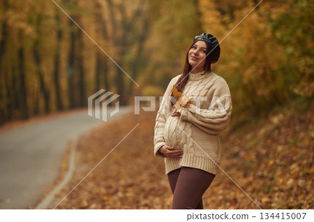 Pregnant woman is standing in the autumn forest Pregnant woman is standing in the autumn forest 134415007