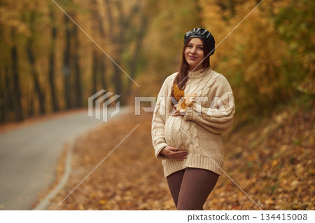 Pregnant woman is standing in the autumn forest Pregnant woman is standing in the autumn forest 134415008