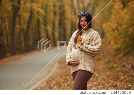 Pregnant woman is standing in the autumn forest Pregnant woman is standing in the autumn forest 134415009