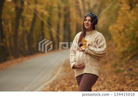 Pregnant woman is standing in the autumn forest Pregnant woman is standing in the autumn forest 134415010