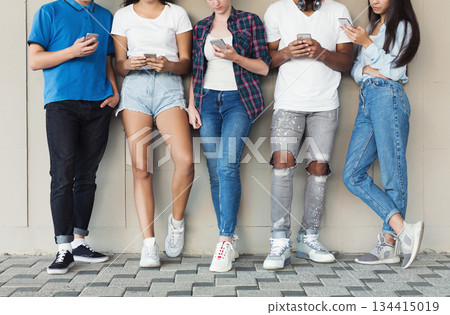 Group of Multicultural Friends Using Smartphones on Urban Background, free space 134415019