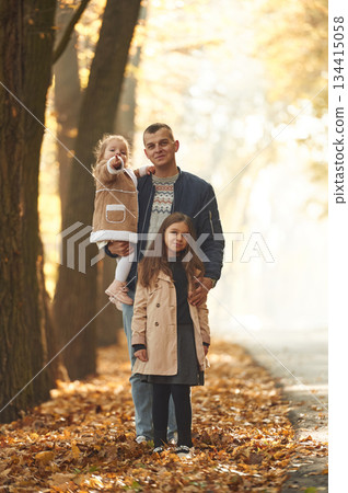 Feeling happy. Father with his daughters in the autumn forest 134415058