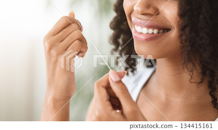 Tooth Care. Unrecognizable black woman with white healthy teeth using dental floss at home, making morning oral care routine 134415161