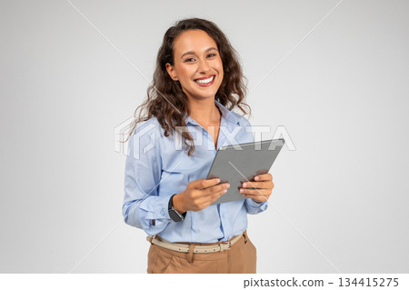 Smiling caucasian young businesswoman use tablet, app for social networks, presentation business, isolated on gray studio background. Work and chat on gadget, study online with technology 134415275