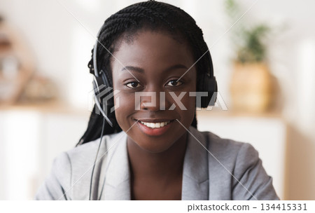 Customer service operator. Portrait of smiling black female call center representative in headset, closeup Customer service operator. Portrait of smiling black female call center representative in headset, closeup 134415331