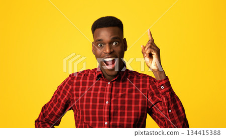 Great Idea. Excited African American Guy Pointing Finger Up And Looking At Camera, Having Inspirational Eureka Moment, Funny Young Man In Checkered Shirt Standing Over Yellow Background, Copy Space Great Idea. Excited African American Guy Pointing Finger Up And Looking At Camera, Having Inspirational Eureka Moment, Funny Young Man In Checkered Shirt Standing Over Yellow Background, Copy Space 134415388