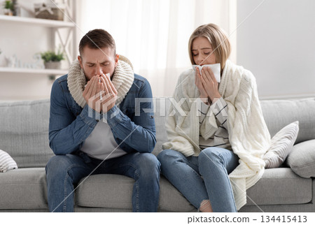 Covid-19 infected family. Sick man and woman coughing at home interior 134415413