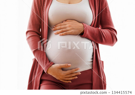 Closeup Shot Of Young Woman Embracing Her Pregnant Belly And Smiling, Millennial Expectant Lady Standing Near Window At Home And Touching Tummy, Enjoying Pregnancy Time, Cropped Image, Copy Space 134415574