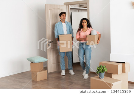 Unhappy confused millennial couple homeowners holding cardboard boxes walking in new house, young family of two people moving into bad flat, sad guy and lady disappointed in interior design Unhappy confused millennial couple homeowners holding cardboard boxes walking in new house, young family of two people moving into bad flat, sad guy and lady disappointed in interior design 134415599