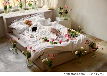 Bright studio with peaceful ambiance, Woman resting amid colorful flower arrangements and sunlight Bright studio with peaceful ambiance, Woman resting amid colorful flower arrangements and sunlight 134415752
