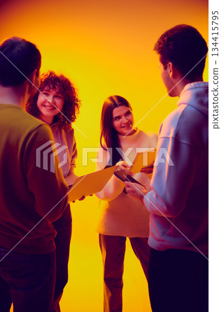 Business team reviewing documents on gadgets together. 134415795