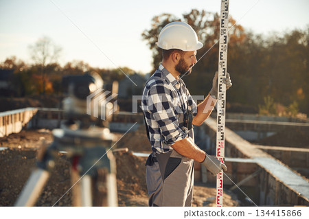 In white hardhat. Worker is on the construction site at daytime 134415866