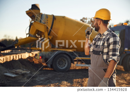 Ready to use concrete that is in the truck. Worker is on the construction site at daytime Ready to use concrete that is in the truck. Worker is on the construction site at daytime 134415928