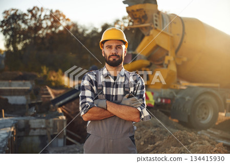 Ready to use concrete that is in the truck. Worker is on the construction site at daytime Ready to use concrete that is in the truck. Worker is on the construction site at daytime 134415930