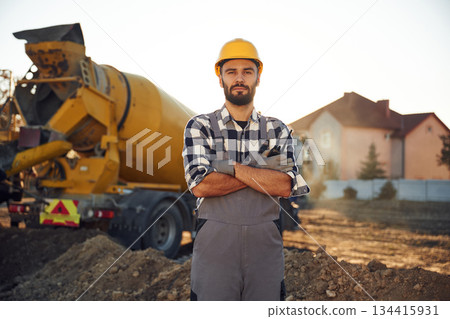 Ready to use concrete that is in the truck. Worker is on the construction site at daytime Ready to use concrete that is in the truck. Worker is on the construction site at daytime 134415931