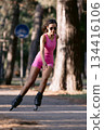 Woman in pink sportwear roller skating in the park, active lifestyle concept. 134416106