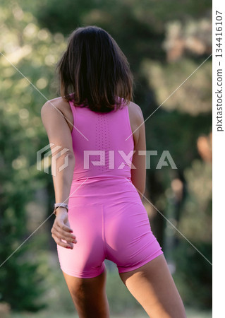 Sporty woman in sportwear roller skating in the park, behind view 134416107