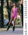 Woman in pink sportwear roller skating in the park, active lifestyle concept. 134416109