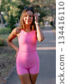 Portrait of beauty woman in pink outfit in sunny park. 134416110