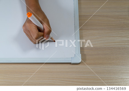 Child's hands writing on a whiteboard 134416569