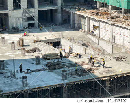 Group of construction worker working on the concrete floor of a building structure. architectural and engineering progress concept. Group of construction worker working on the concrete floor of a building structure. architectural and engineering progress concept. 134417102