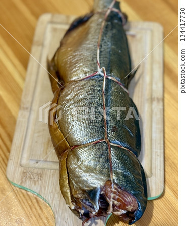 Cold hot smoked mackerel, beautifully laid out on a wooden chopping board, is ready for cooking and serving and is perfect for culinary themes. 134417750