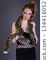 Beautiful redhead girl posing with her pet snake in the studio 134418052