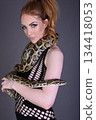 Beautiful redhead girl posing with her pet snake in the studio 134418053