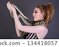Beautiful redhead girl posing with her pet snake in the studio 134418057