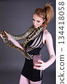 Beautiful redhead girl posing with her pet snake in the studio 134418058
