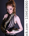 Beautiful redhead girl posing with her pet snake in the studio 134418060