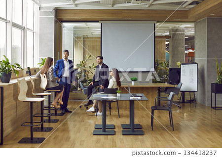 Team of four young people meeting in a modern office interior in a business center Team of four young people meeting in a modern office interior in a business center 134418237