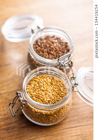 Golden linseed or flaxseed. Healthy flax seed in jar on wooden table. 134419254