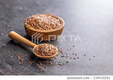Linseed or flaxseed. Healthy flax seed on wooden spoon on black table. Linseed or flaxseed. Healthy flax seed on wooden spoon on black table. 134419262