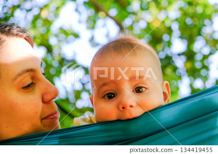 Child Peeking Over Hammock in Park 134419455
